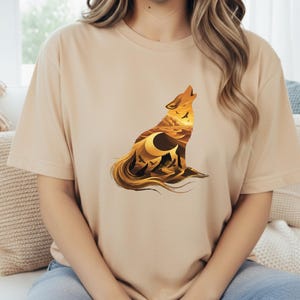 A woman wearing a sand-colored t-shirt that perfectly matches the "Desert Nomad" theme of the saguaro and canyon artwork.