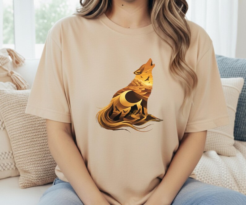 A woman wearing a sand-colored t-shirt that perfectly matches the "Desert Nomad" theme of the saguaro and canyon artwork.