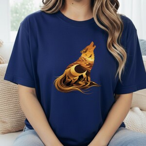 A woman in a navy blue t-shirt where the dark fabric creates a night-sky effect behind the warm golden desert wolf artwork.