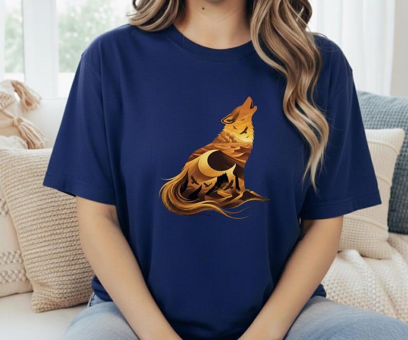 A woman in a navy blue t-shirt where the dark fabric creates a night-sky effect behind the warm golden desert wolf artwork.