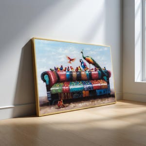 May include: A framed artwork depicts a colorful sofa with various birds perched on it. A peacock and other birds are on the sofa. The artwork has a gold frame and is leaning against a white wall and wooden floor.
