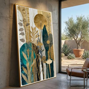 May include: A framed abstract art print featuring botanical elements in gold, teal, and white. The artwork includes stylized leaves, a large circular shape, and vertical gold accents. The print is displayed against a concrete wall near a window.