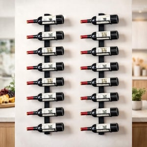 May include: Two black metal wine racks, each holding six bottles of red wine. The wine bottles are black with white labels and red foil around the neck. The racks are mounted on a white wall.