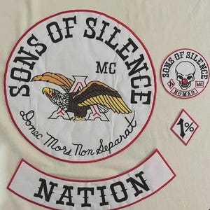 May include: A set of white embroidered patches with red borders. The large circular patch features a black eagle, the text "SONS OF SILENCE MC" and "Donec Mors Non Separat". A smaller circular patch shows a skull with a red nose, and a diamond patch says "1%".