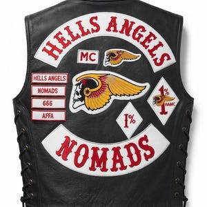 Puede incluir: Un chaleco de cuero negro con parches bordados que incluyen el texto HELLS ANGELS, NOMADS, MC, 666, AFFA y 1%. La parte posterior muestra un gran emblema de calavera alada, con detalles de cordones laterales y letras en rojo y blanco.