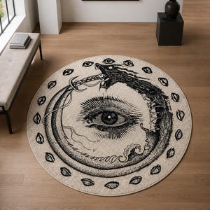Könnte beinhalten: Ein runder Teppich mit einer schwarz-weißen Illustration einer Ouroboros-Schlange, die sich in den eigenen Schwanz beißt und ein großes zentrales Auge umschließt. Der Rand ist mit einem Muster aus kleinen, einzelnen Augenmotiven verziert.