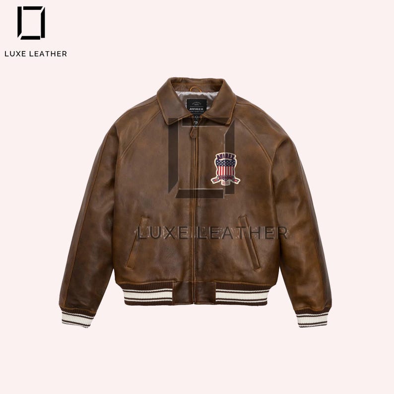 Puede incluir: Chaqueta bomber de cuero marr&oacute;n con cierre de cremallera, cuello y parche en el pecho. La chaqueta tiene pu&ntilde;os y dobladillo a rayas blancas y marrones. La marca "LUXE LEATHER" est&aacute; impresa en la chaqueta.