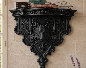 May include: Black decorative wall shelf with a wolf head carving. The shelf has ornate detailing, a carved wolf head, and is mounted on a brick wall. A book, glasses, and a feather are on the shelf.