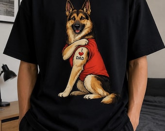 May include: A black short-sleeved t-shirt featuring a graphic of a German Shepherd dog wearing a red t-shirt. The dog has a tattoo on its upper arm that displays the text I heart DAD, with a red heart symbol representing the word heart.