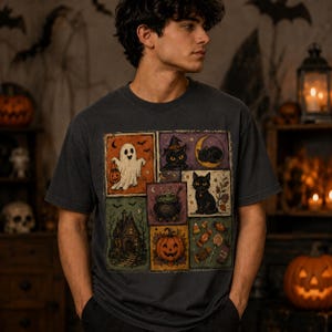 May include: A charcoal gray short-sleeve t-shirt featuring a multi-panel graphic print. The design includes a white ghost with a pumpkin, a black cat in a witch hat, a crescent moon, a bubbling cauldron, a haunted house, and assorted candy.
