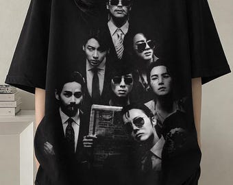 Puede incluir: Camiseta negra de manga corta con una imagen en escala de grises de un grupo de personas con trajes y gafas de sol. La imagen está impresa en la parte delantera.