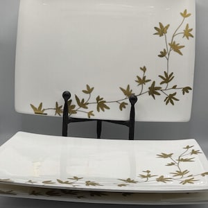 May include: A white ceramic mug with a black handle and the text "But First, Coffee" in a black, bold font. The mug is on a white surface.