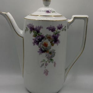 Cioccolatiera antica in porcellana Zeh Scherzer Bavaria con decorazioni floreali color lilla e rosa e finiture dorate.