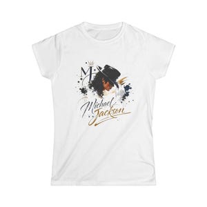 May include: White t-shirt with a graphic of Michael Jackson wearing a black hat, and the name "Michael Jackson" in gold script. The design includes a crown and navy and black paint splatters.