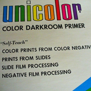 May include: A vintage instructional manual cover titled unicolor COLOR DARKROOM PRIMER. The text includes Self-Teach, COLOR PRINTS FROM COLOR NEGATIVES, PRINTS FROM SLIDES, SLIDE FILM PROCESSING, and NEGATIVE FILM PROCESSING in black on a cream background.
