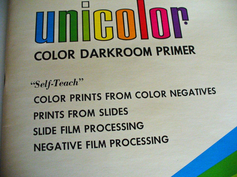 May include: A vintage instructional manual cover titled unicolor COLOR DARKROOM PRIMER. The text includes Self-Teach, COLOR PRINTS FROM COLOR NEGATIVES, PRINTS FROM SLIDES, SLIDE FILM PROCESSING, and NEGATIVE FILM PROCESSING in black on a cream background.