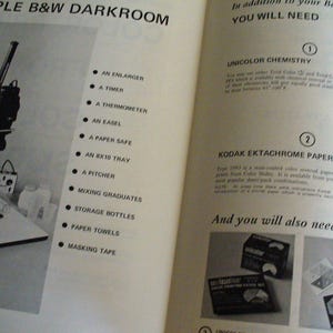 May include: An open instructional book page titled A SIMPLE B&W DARKROOM featuring a black and white photograph of a photographic enlarger and a list of equipment including a timer, thermometer, easel, paper safe, tray, pitcher, and bottles.