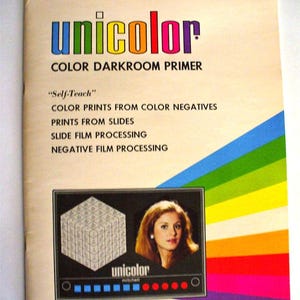 May include: A vintage Unicolor Color Darkroom Primer instructional booklet with a rainbow-striped design. The cover features the text "Self-Teach" and lists darkroom processes, including a graphic of a cube and a portrait of a person.