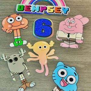 May include: A selection of cartoon character cutouts, featuring a rainbow arch with the name "DEMPSEY" and a glittery blue number "6". The characters are from "The Amazing World of Gumball" animated series.