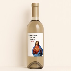 May include: A clear wine bottle with a gold-colored cap. The label features the text "This Used To Be Water AD 33" above an image of Jesus Christ.