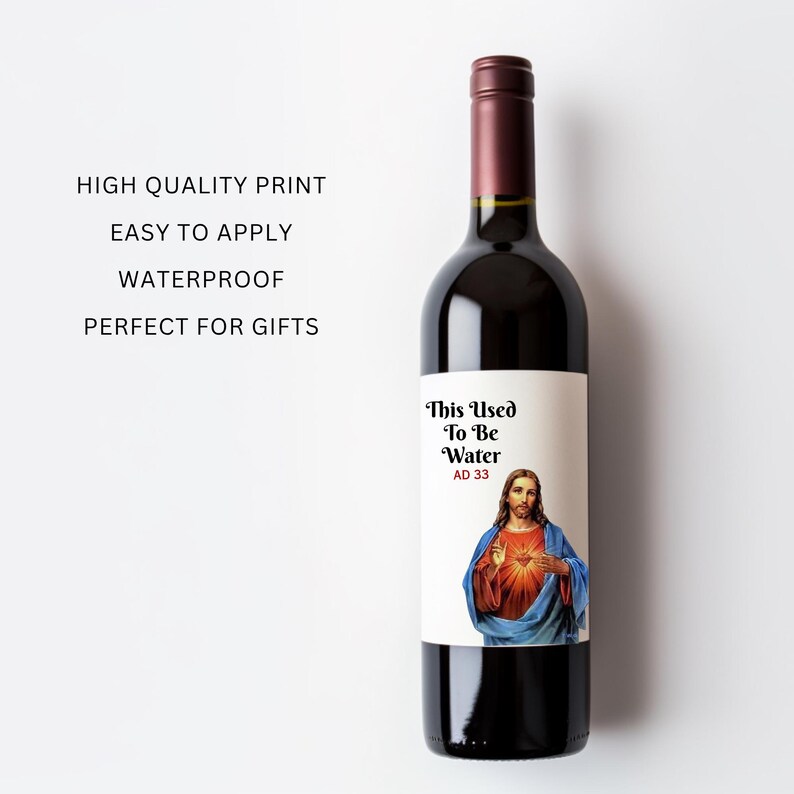 May include: A wine bottle with a label that reads "This Used To Be Water AD 33". The label features an image of Jesus. The bottle is filled with red wine and has a dark burgundy cap.