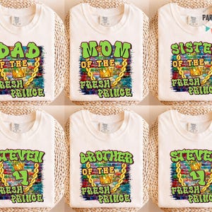 May include: Six white t-shirts with different text designs. The shirts say "DAD", "MOM", "SISTER", "STEVEN", "BROTHER", and "STEVEN" in green and yellow lettering. Each design includes a crown and the words "FRESH PRINCE".