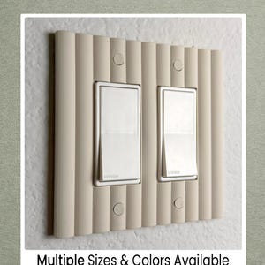 May include: Beige light switch cover with two switches and a textured, vertical ribbed design. The switches have a silver trim and the text "Multiple Sizes & Colors Available" is at the bottom.