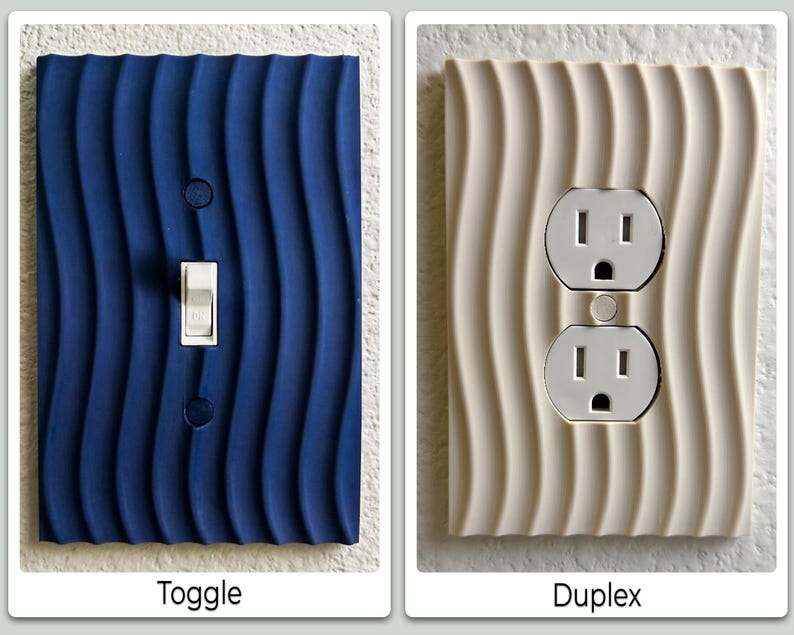 May include: Two electrical outlet covers. One is a dark blue toggle switch cover with a wavy pattern. The other is a cream-colored duplex outlet cover with a similar wavy design. The text below the blue cover says "Toggle", and the text below the cream cover says "Duplex".