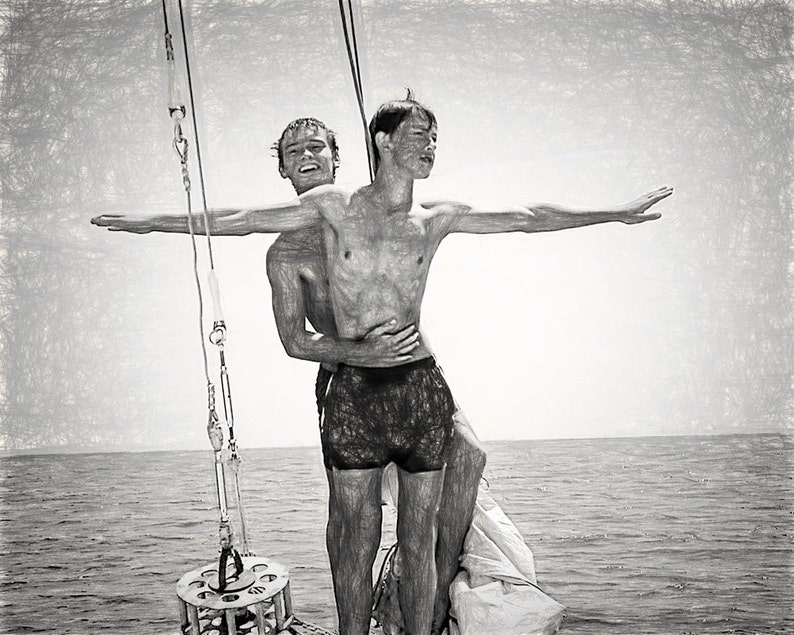 May include: Two young men stand on a boat, one with his arms outstretched, the other holding him from behind. The men are wearing swim trunks and are on a boat in the middle of the ocean.