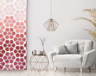 May include: A white armchair with a tufted back and two pillows sits in a room with a white wall and a geometric patterned curtain. A gold metal side table with a geometric design sits in front of the chair. A small potted plant sits on the table.