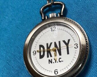 Reloj de bolsillo DKNY plateado con cadena plateada, cuarzo, funciona, pila nueva.