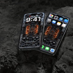May include: Two smartphones with black frames and dark, intricate mechanical-style wallpapers featuring orange glowing internal components. The screens display a digital clock reading 9:41, date, and various app icons including camera, settings, and mail.