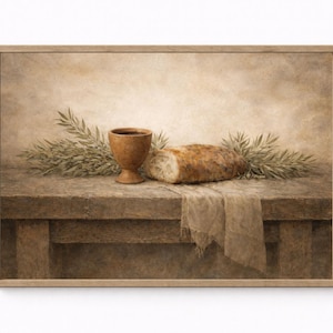 Może przedstawiać: Oprawiona martwa natura przedstawia drewniany kielich, bochenek chleba i gałązki zieleni na rustykalnym stole. Scena jest skąpana w ciepłych, ziemistych tonach, tworząc spokojną atmosferę. Stół jest przykryty lnianą szmatką.