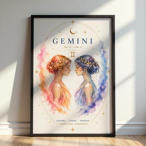Könnte beinhalten: Ein gerahmter Kunstdruck des Sternzeichens Zwillinge. Die Aquarellillustration zeigt zwei Frauen, die sich gegenüberstehen, umgeben von farbenfrohen, ätherischen Wolken. Der Druck enthält das Wort "GEMINI" und die Daten "21. MAI - 20. JUNI".