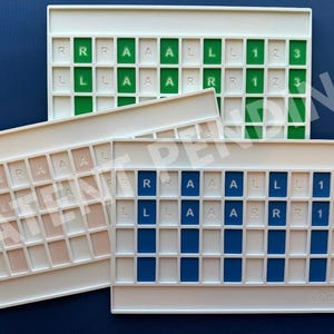 Op de afbeelding: Drie rechthoekige witte kunststof organizers met rastervakken. Elke organizer heeft gekleurde inzetstukken in groen, blauw of beige. De inzetstukken zijn bedrukt met de letters R, A, L en de cijfers 1, 2, 3 in een herhalend patroon.