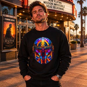 Black graphic sweatshirt with colorful sci fi mandolorian style helmet art, geometric armor design, and gamer streetwear style.