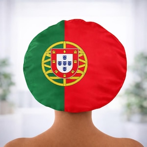 May include: A round, green and red head covering featuring the Portuguese flag. The flag design includes a coat of arms with a gold border and five blue shields.