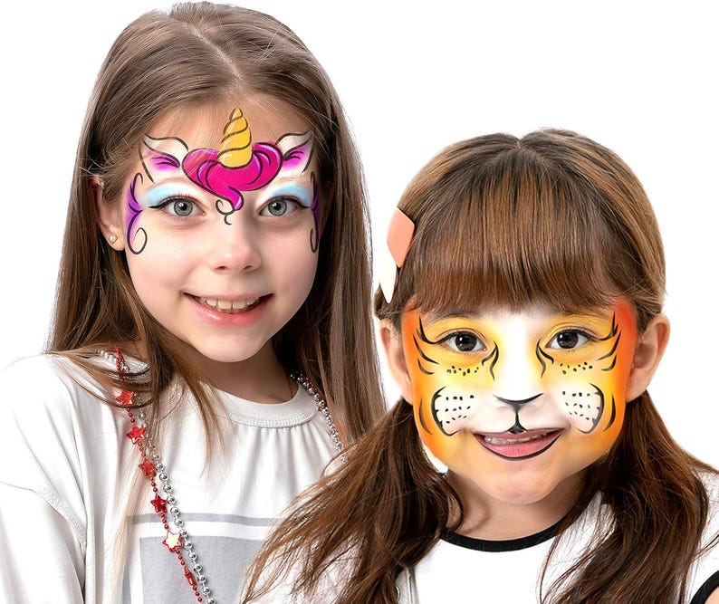 Op de afbeelding: Twee jonge mensen met schmink. E&eacute;n heeft een eenhoornontwerp met roze, paarse en gele accenten. De ander heeft een tijgerontwerp met oranje, gele en zwarte details. Beide lachen en dragen witte shirts.