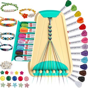 Può includere: Un kit per creare braccialetti dell'amicizia. Il kit include un telaio per braccialetti, filo da ricamo colorato, perline e bottoni decorativi. Vengono mostrati diversi braccialetti finiti, insieme al testo "DREAM" e "HEY GIRL".