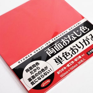 Könnte beinhalten: Ein Paket rotes Origami-Papier, 150 mm x 150 mm, mit japanischem Text und Illustrationen. Der Text auf der Verpackung lautet "RYOMEN ONAJI IRO TANSHOKU ORIGAMI". Geeignet für Origami und Papierarbeiten.