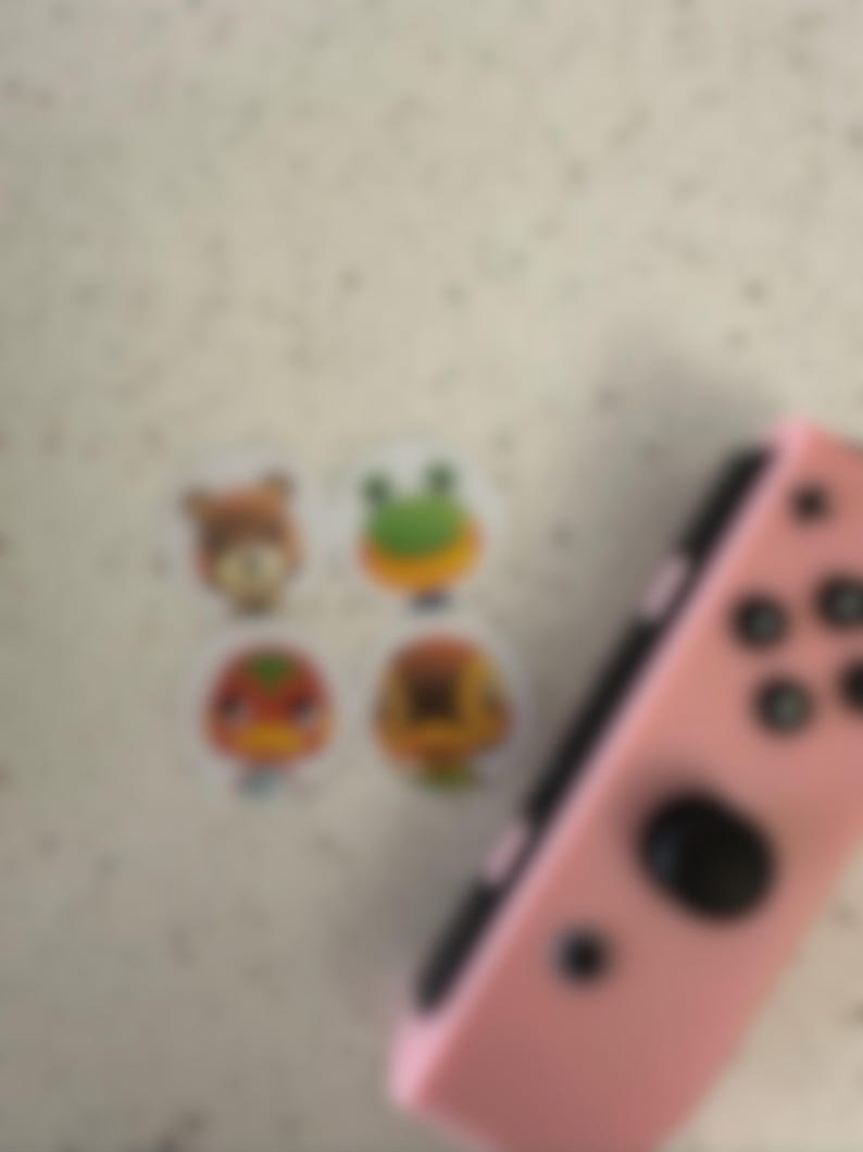 May include: A white ceramic mug with a black handle and the text "But First, Coffee" in a bold, black font. The mug is set against a blurred background, suggesting a cozy setting. The mug appears to be approximately 4 inches tall.