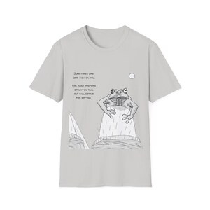 May include: A light gray t-shirt featuring a cartoon illustration of a frog with the text "Sometimes life gets high on you. Mr. Toad prefers spray-on tan, but will settle for SPF-50."