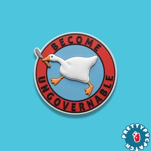 May include: A round patch with a white goose holding a silver knife, inside a red circle with the words "BECOME UNGOVERNABLE". The goose is on a light blue background. The patch has a white border and a small logo in the bottom right corner.