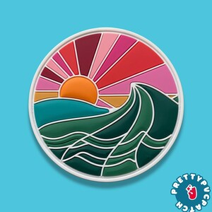 May include: A round patch featuring a sunset over ocean waves. The design includes an orange sun, pink and red rays, and green waves. The patch has a white border and the text "PRETTYPUC PATCH".