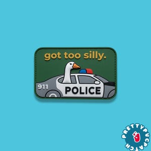 May include: A rectangular green patch featuring a white goose with an orange beak leaning out of a gray police car. The text "got too silly." is printed in yellow above the car, with "911" and "POLICE" in black on the side of the vehicle.