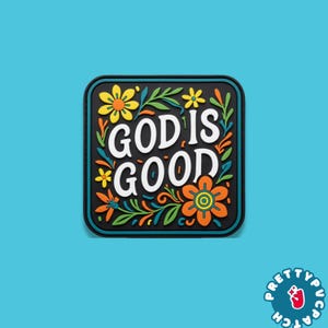 May include: A square patch with rounded corners, featuring the words "GOD IS GOOD" in white, surrounded by colorful floral designs. The patch has a black background and a blue border.