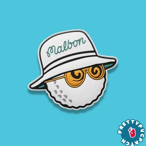 May include: A white golf ball wearing a white hat with the word "Malbon" in green script, and gold sunglasses. The golf ball is on a light blue background. The image has a cartoon style.