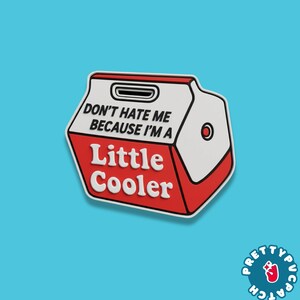 May include: A red, white, and black patch in the shape of a cooler. The patch has the words "DON'T HATE ME BECAUSE I'M A" above "Little Cooler". The patch is on a blue background.