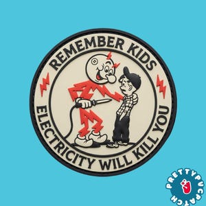May include: A circular PVC patch featuring a cartoon character made of red lightning bolts holding a soldering iron near a young person. The cream-colored background includes the black text REMEMBER KIDS ELECTRICITY WILL KILL YOU.