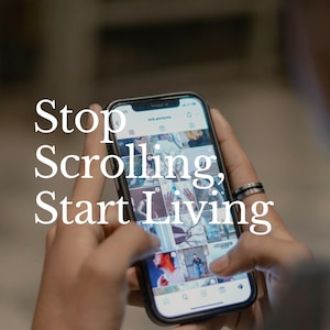 May include: A smartphone displaying a social media feed, held by a person. The screen shows various images. The phone has a black case and a silver ring is on the person's finger. Text on the screen reads "Stop Scrolling, Start Living."